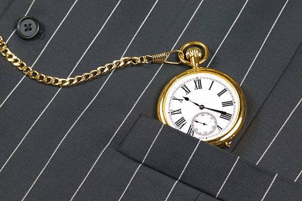 Pocket watch and waistcoat Gold pocket watch with roman numerals in the pocket of a waistcoat pocket watch vest stock pictures, royalty-free photos & images
